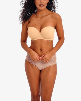 Modell bär ett beige underklädesset med axelbandslös BH och beige transparent boxertrosa med ränder, visat framifrån 