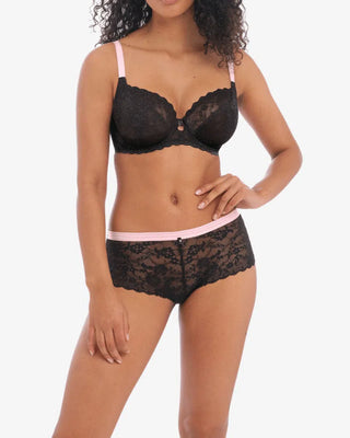 Modell bär ett set med svart spets-BH och matchande hipstertrosa med rosa midjeresår, perfekt som elegant vardagsunderkläder

