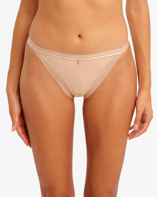 Närbild på Freyas beiga trosa i mesh, på modell. Designen har låg midja och ett diskret, geometriskt mönster framtill samt en tunn, dubbel resår i linningen.

