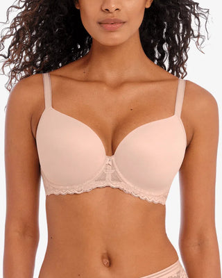 Modell bär Freya-bh i ljusbeige med rundade kupor och spetskant under bysten. Den lilla rosetten med pärla framtill ger en elegant och feminin touch.

