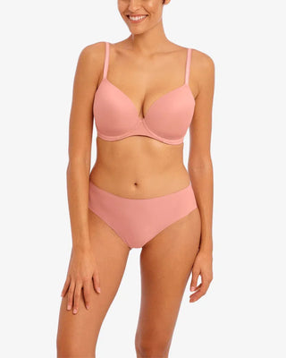 Modell bär ett set med rosa t-shirt-BH och matchande trosor, fotad framifrån. Perfekt för vardagskomfort och en osynlig finish under kläder.


