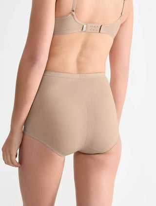 Modell bär Sloggi 3-pack Basic+ maxitrosor i färgen skin, sedd bakifrån