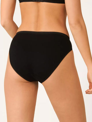 Modell bär Sloggi 3-pack Basic+ svarta taitrosor, sedd bakifrån