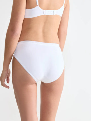 Modell bär Sloggi 3-pack Basic+ vita taitrosor, sedd bakifrån