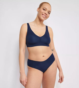 “Modell bär marinblå Sloggi Zero Feel bralette – sömlös bh med avtagbara vadderingar, 360° stretch och osynlig passform.”