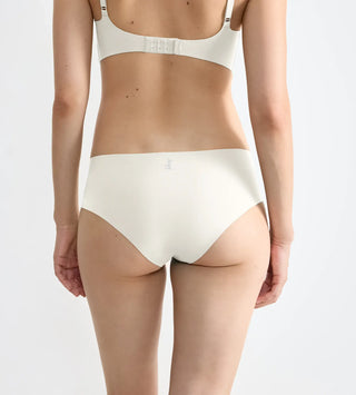 “Närbild på tyg i vit Zero Feel hipstertrosa – supermjuk återvunnen polyamid med dot bonding och fukttransporterande Activated Silk™.”