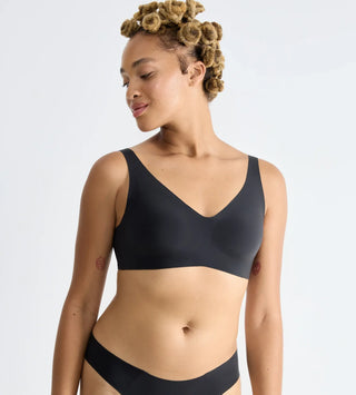 “Halvbild framifrån av svart Sloggi Soft Bra – följsam bh med V-ringning, lätt stöd och sömlös komfort utan byglar.”
