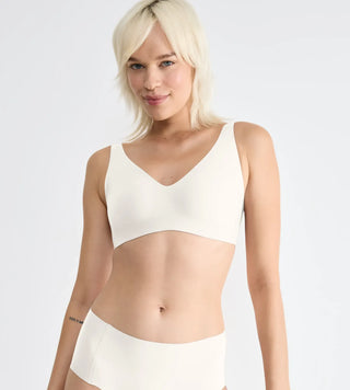 “Halvbild framifrån av vit Sloggi Soft Bra – följsam bygellös bh med lätt vaddering och osynlig finish under kläder.”