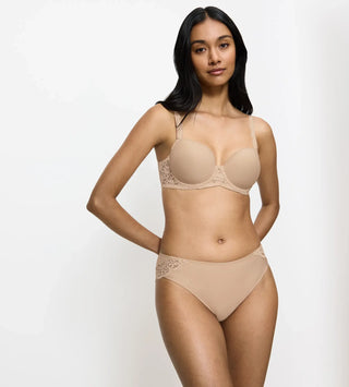 Modell bär Triumph Amourette Tai trosa i färgen skin framifrån – elegant spets och bekväm passform i feminin design.