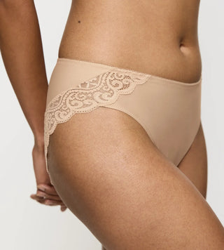 Sidovy av Triumph Amourette Tai trosa i färgen skin på modell – visar midjehöjd och fin spets längs kanterna.