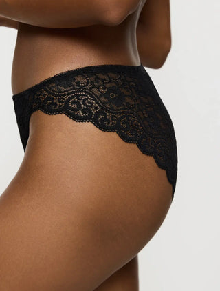 Sidovy av svart Triumph Amourette Tai trosa på modell – visar midjehöjd och fin spets längs kanterna.