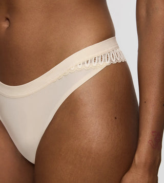 Triumph Aura Spotlight High Leg Stringtrosa - Beige härlig och fin strintrosa trosa fotad mot en grå bakgrund 