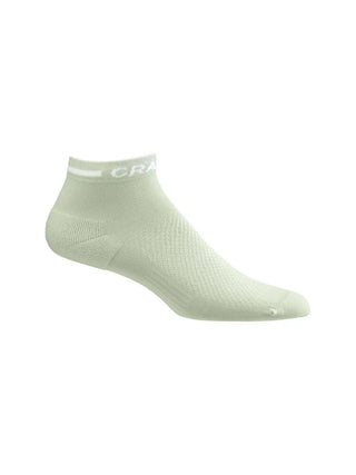 Craft CORE Dry Mid strumpor i ljusgrön  designade för effektiv fukttransport och medelhög längd vid träning visas från sidan mot en vit bakgrund. 