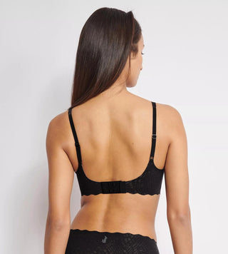 Modell bär sloggi ZERO Feel Bliss Soft Bra bakifrån – visar hak- och hyskstängning, justerbara band och spetsrygg