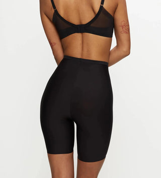 Modell bär Triumph Smart Series Soft Shaping Panty bakifrån, framhäver sömlös passform och diskret shaping