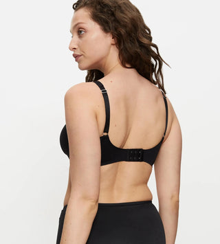 Bh utan bygel sedd bakifrån på modell, med bred ryggdel och släta kanter för osynlig passform under kläder.