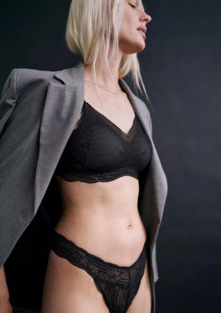 Modell poserar i Triumph Lace Series Brazilian Brief och matchande spets-BH, visar helhetslook och passform