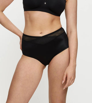 Shape Sensation Maxi Brief i svart sedd framifrån på modell, visar meshdetaljer på midjan och elastisk tejp.