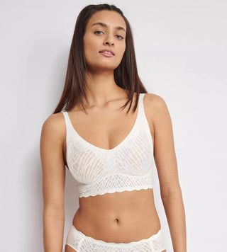 Modell bär vit sloggi ZERO Feel Bliss V-neck bralette framifrån – elegant spets och sömlös passform med naturlig siluett